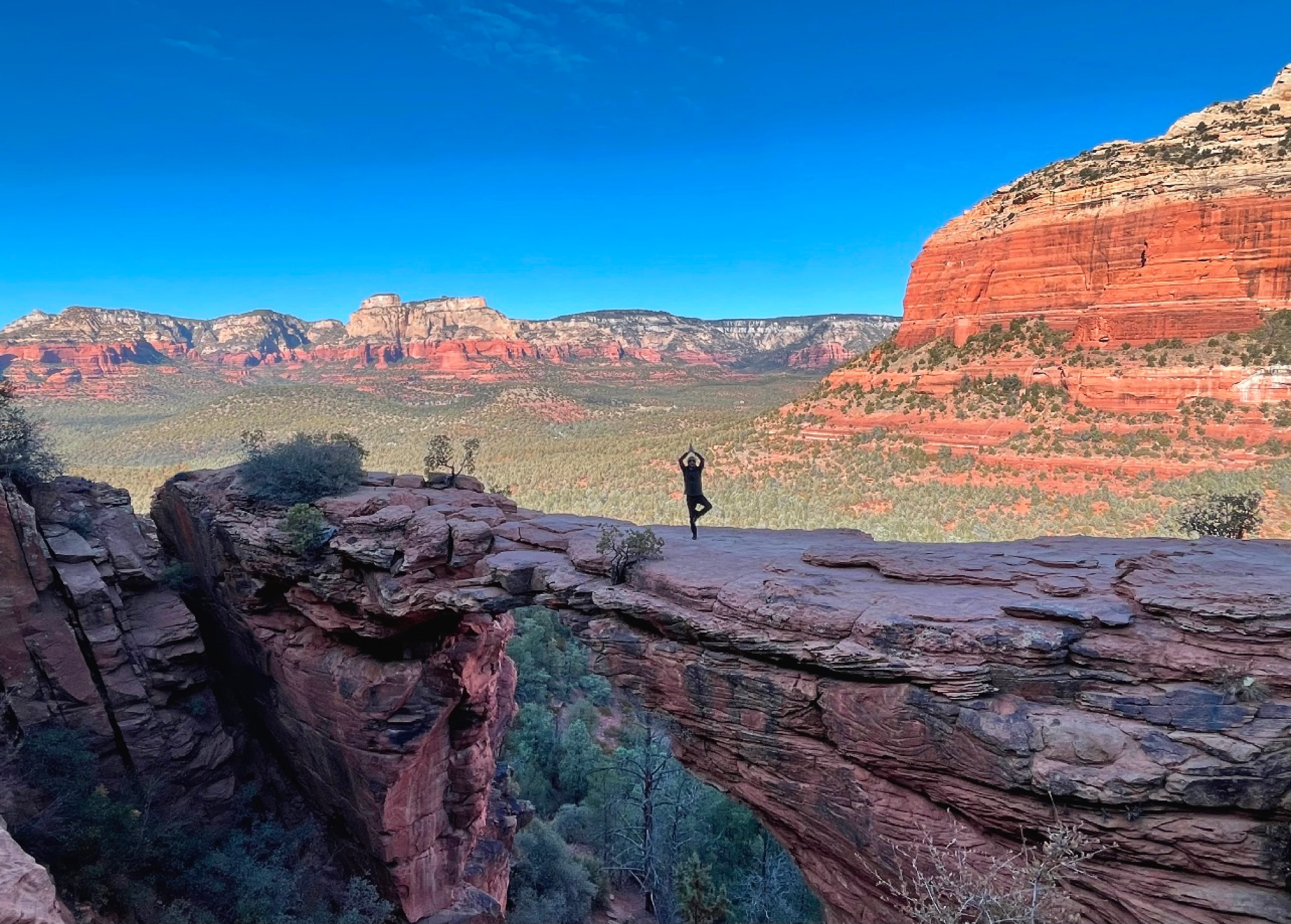 Machiel Bornman in tree pose on a rock bridge in Sedona
